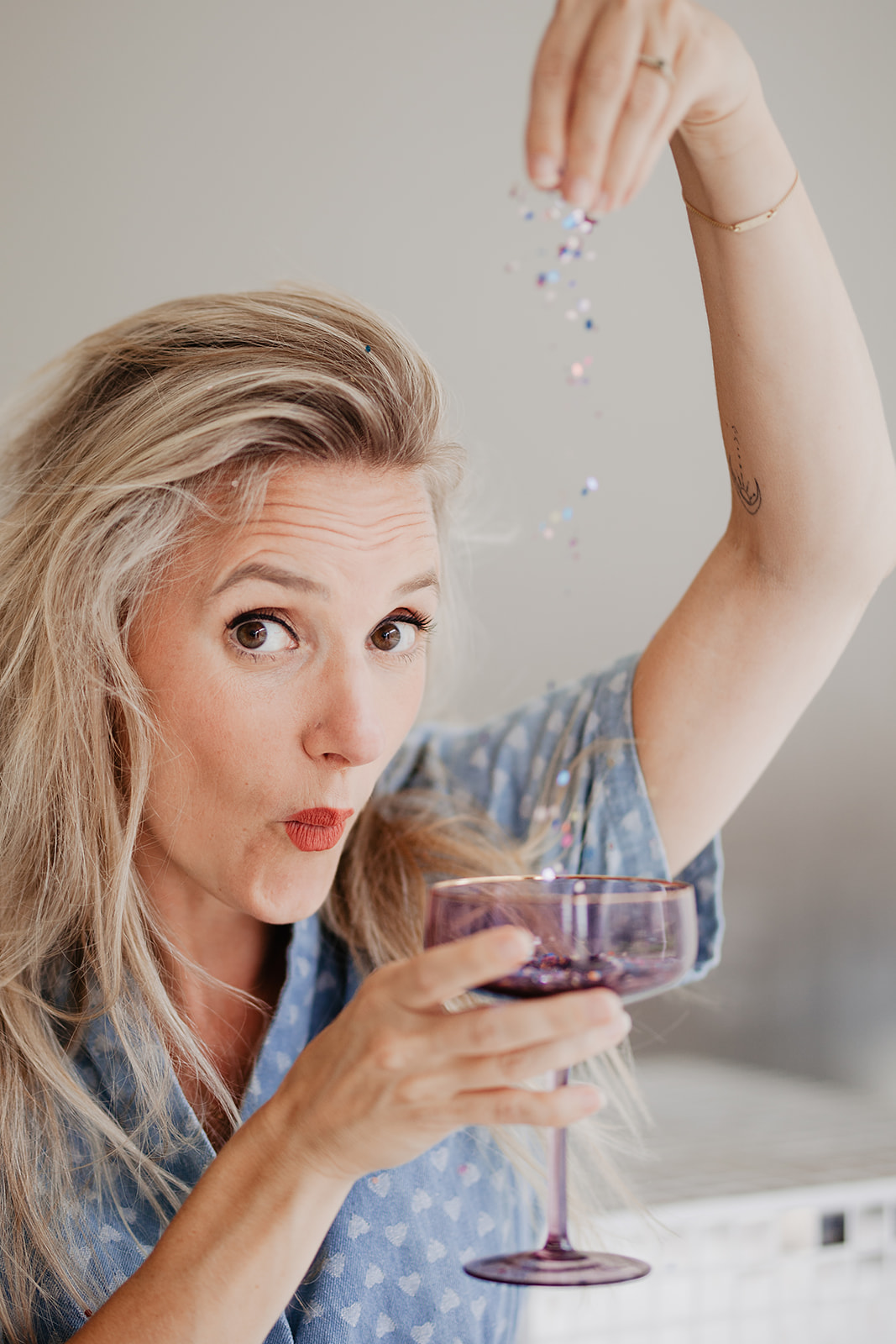 Lena met een glas en confetti, uitnodigend en speels